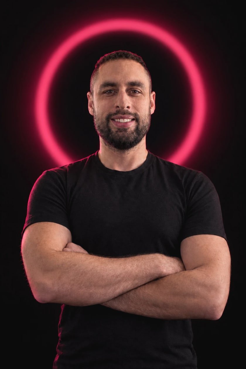 Rubén Villarroya, fondateur d’Attira, agence web à Fribourg, les bras croisés devant un anneau de lumière bordeaux.
